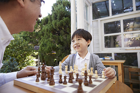 微笑祖父孙子下国际象棋图片