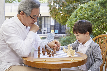 微笑祖父孙子下国际象棋图片