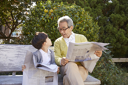 祖父孙子一起在长凳看报纸图片