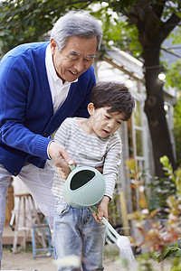 祖父孙子给花浇水图片