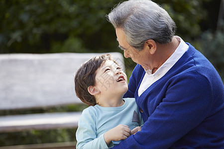 蓝色的石头抱着孙子开心的祖父背景