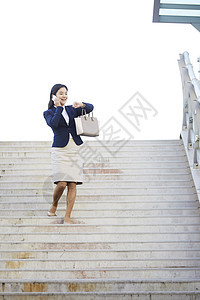 接着电话走下楼梯的年轻女性图片