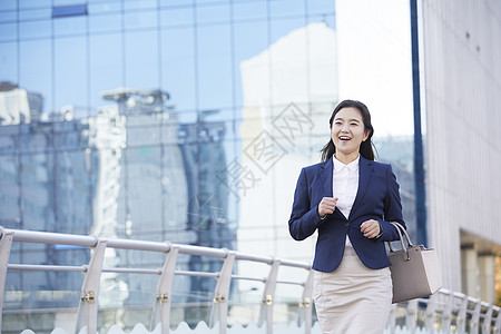 穿着职业装拿着挎包开心的成年女子图片