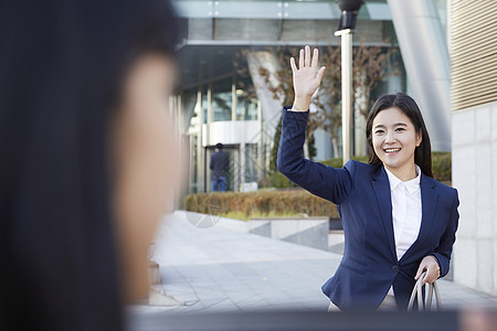 微笑招手的年轻女性图片素材