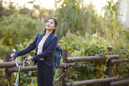 背着书本推着自行车的年轻女子图片