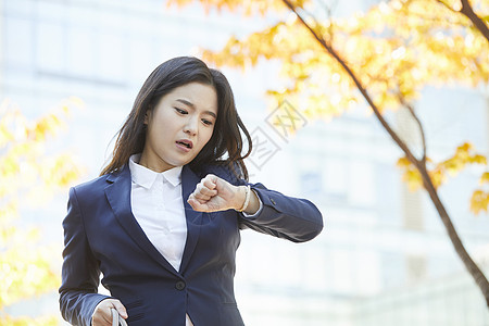 看着手表时间焦急的年轻女子图片