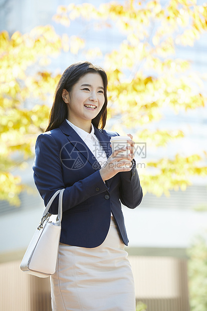 拿着咖啡微笑的女青年图片