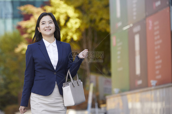 提着手提包微笑的成年女子图片