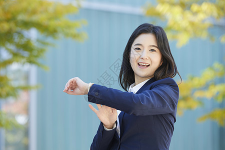 看着手表微笑的年轻女子图片