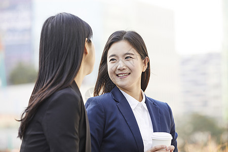 拿着咖啡微笑的青年女性图片