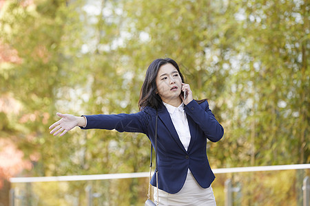 站在路边打电话拦着的女青年图片