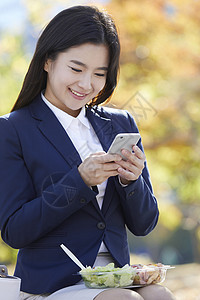 看着手机微笑的年轻女子图片