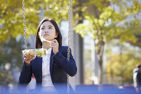 户外吃着沙拉的年轻女性图片