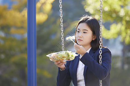 看着沙拉的忧郁的年轻女子图片