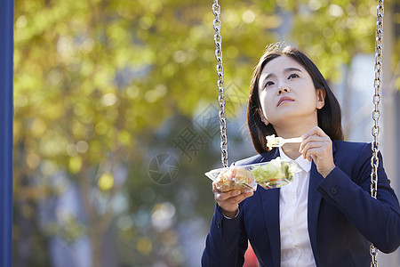 年轻女子孤独的吃着沙拉图片