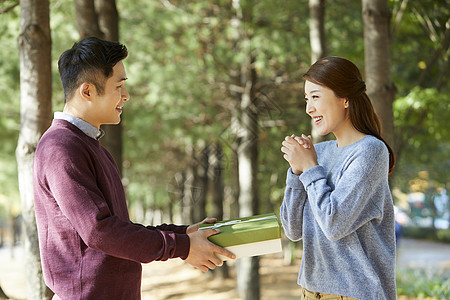 年轻夫妻在公园里送礼物图片