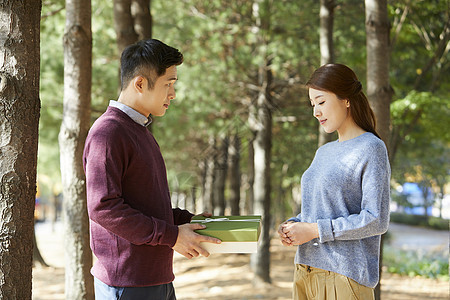 年轻夫妻在公园里送礼物图片