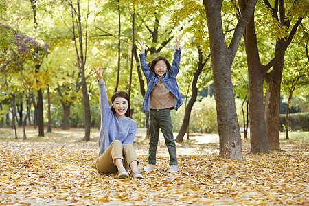 秋天妈妈陪孩子在公园里玩耍图片