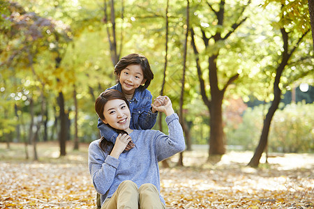 秋天妈妈陪孩子在公园里玩耍图片