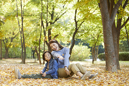 秋天妈妈陪孩子在公园里玩耍图片