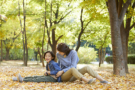 秋天妈妈陪孩子在公园里玩耍图片