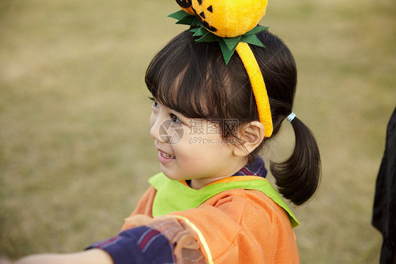 户外草地上万圣节装扮的小女孩开心玩耍图片