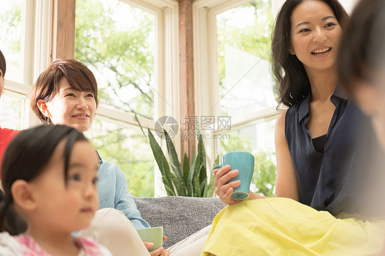 父母和小孩玩女人放松在客厅的妈妈朋友图片