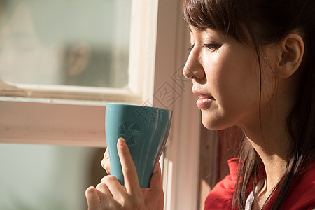 一个女人在窗口喝咖啡图片