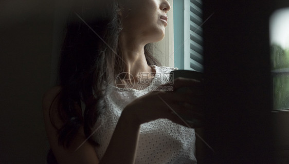 一个女人喝咖啡看向窗外图片