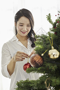 年轻女人装扮圣诞树图片