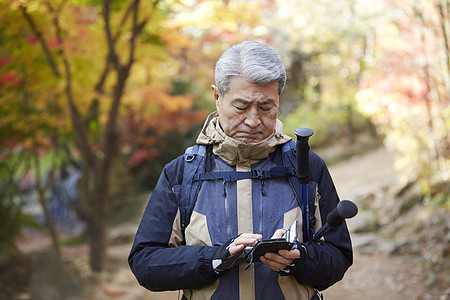 老人户外登山观光看手机图片