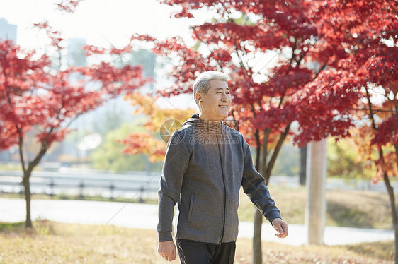 秋天在公园里散步的中年男子图片
