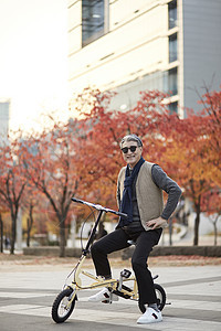 秋天老人在户外骑自行车图片