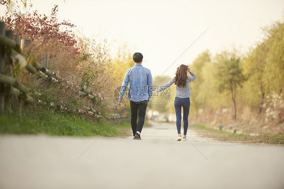 公园里散步约会的情侣背影图片