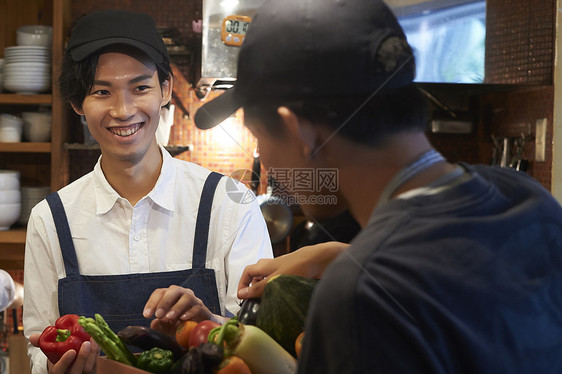 在咖啡店厨房认真工作的年轻男女图片