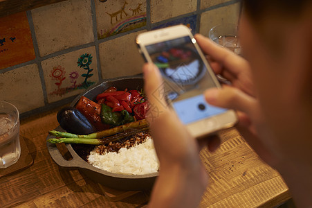 咖喱非常热回锅男子用智能手机拍摄食物图片