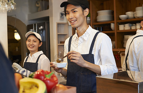 在咖啡店厨房认真工作的年轻男女图片