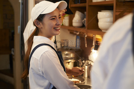 在咖啡店厨房认真工作的年轻男女图片