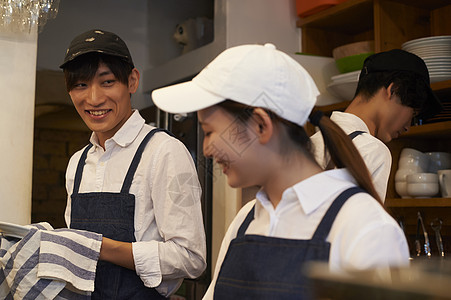 在咖啡店厨房认真工作的年轻男女图片