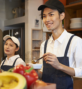 在咖啡店厨房认真工作的年轻男女图片