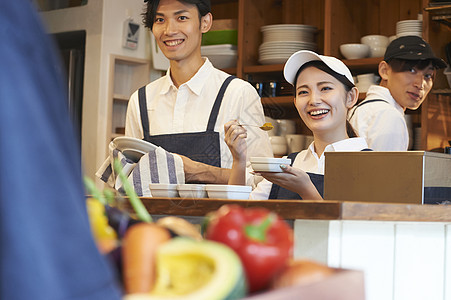 在咖啡店厨房认真工作的年轻男女图片