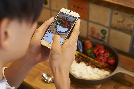 座席20多岁图画男子用智能手机拍摄食物图片
