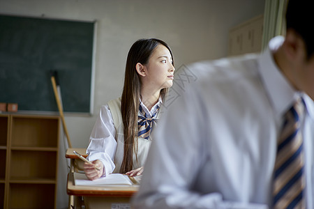 坐女士天学生在教室里学习图片