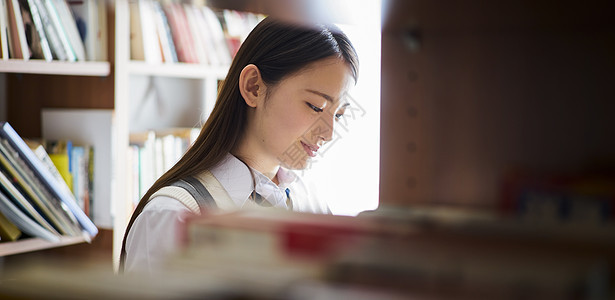 高兴明亮女图书馆里的学生图片