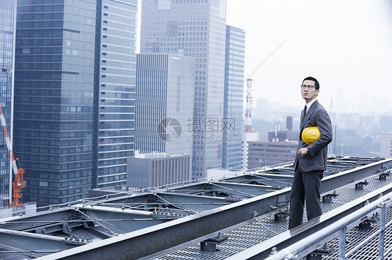 站立在屋顶的建筑商人图片