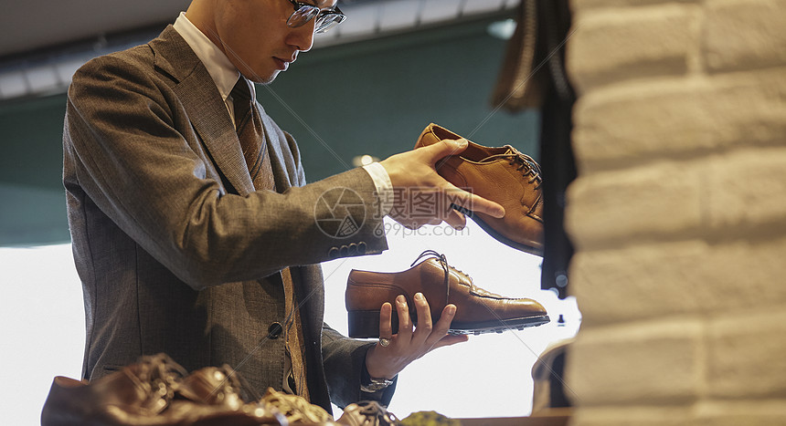 服装店挑选皮鞋的男士图片