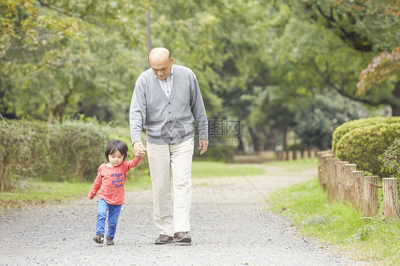 微笑的爷爷和孙子一起玩散步图片