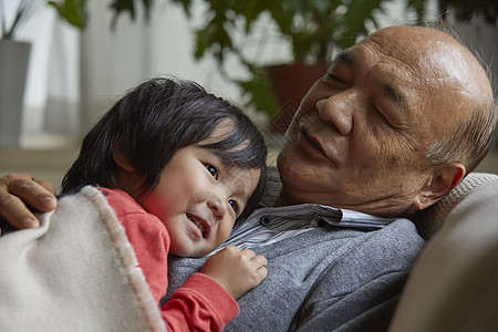 微笑的爷爷抱着孙子一起玩图片