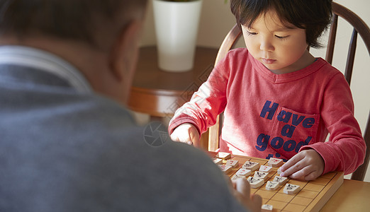 爷爷看护指导孙子学习将棋图片