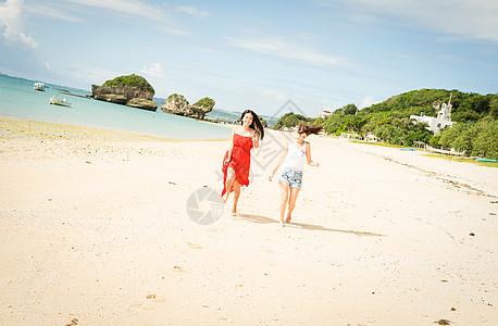 微笑远足在冲绳海滩旅行的妇女图片